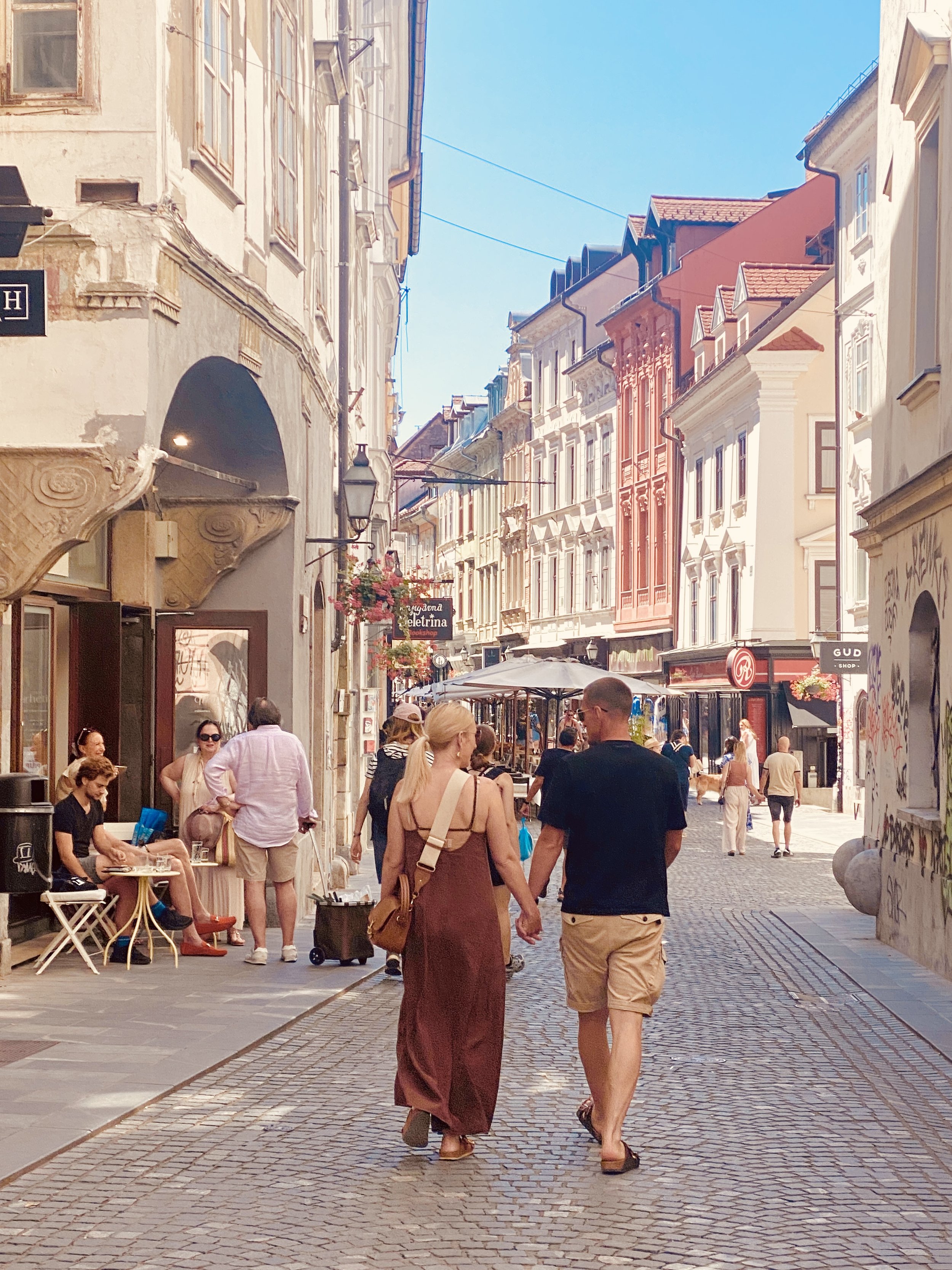 couple walking down a historic street in ljubljana, slovenia