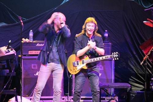 Normally stoic Steve Hackett laughing and clapping his hands instead of playing guitar
