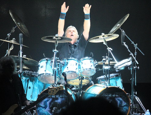 Kansas drummer Phil Ehart throwing his arms up at the end of the band’s concert