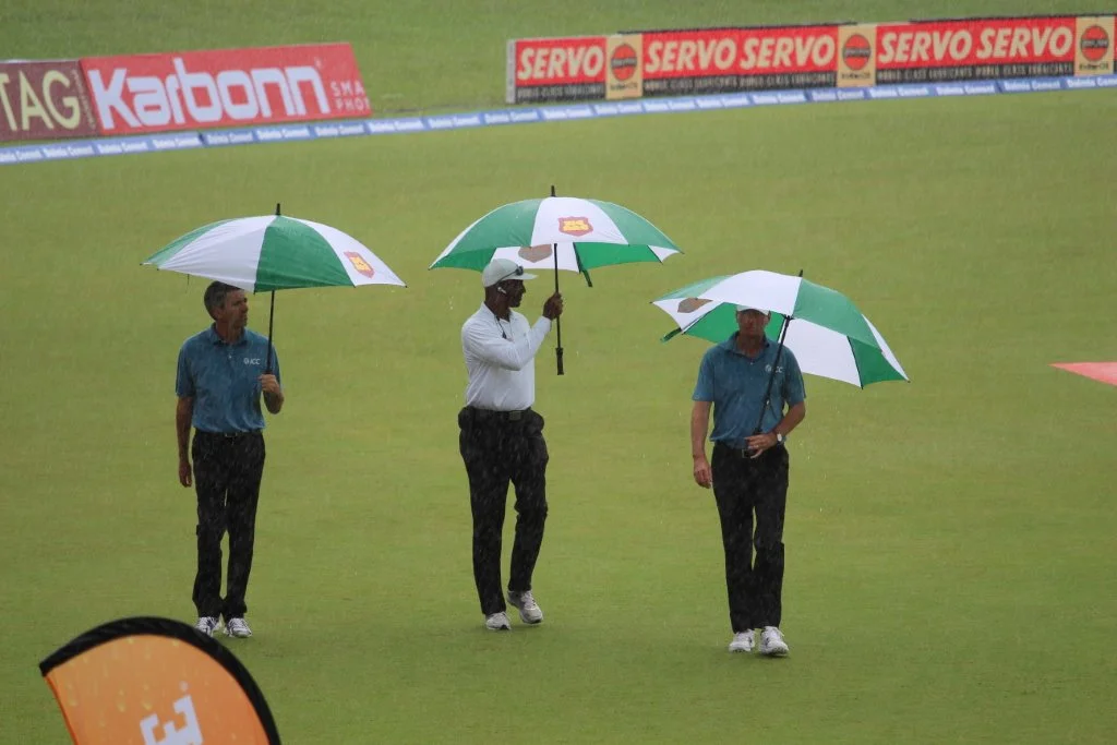 Umpires for the fourth “test” match between India and the West Indies at the Queen’s Park Oval in Trinidad in August are caught in the rain while inspecting the field following an earlier downpour. (Photo by Ewart Rouse. All rights reserved)