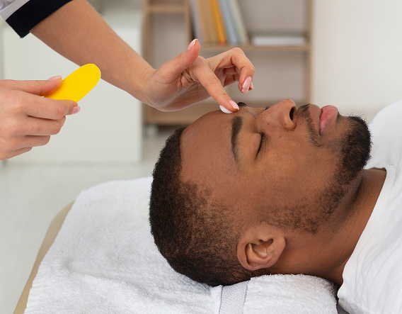 A man gently cleanses his face, demonstrating how to maintain healthy healing after a chemical peel.