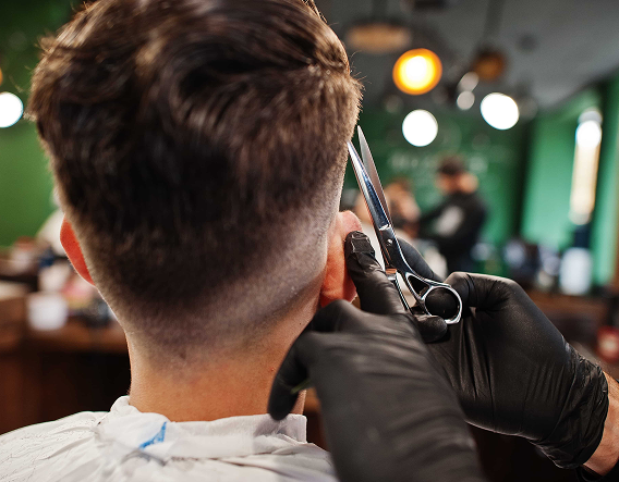 Modern fade haircut with textured top being finished by a professional barber in Buena Park