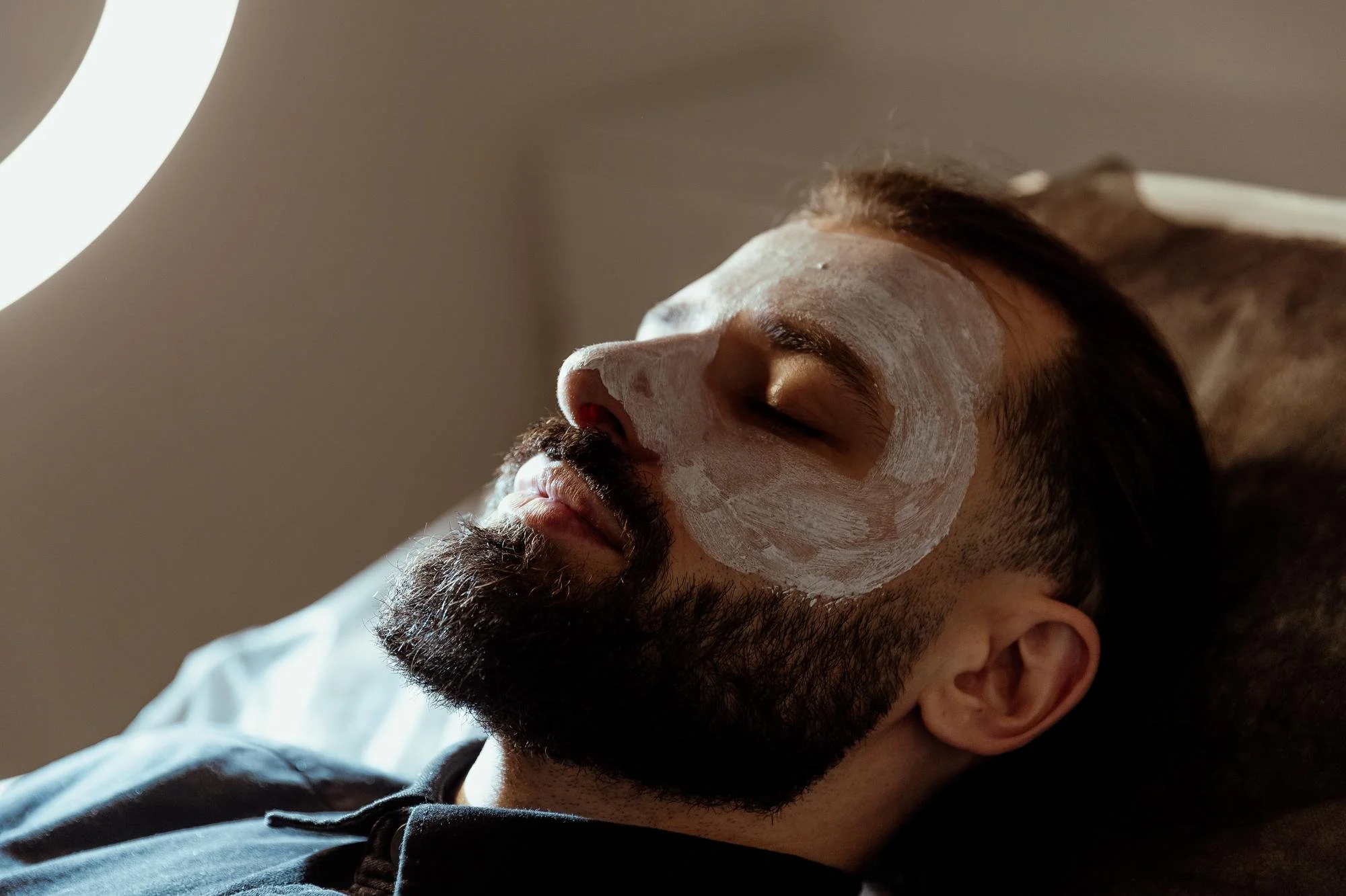 Client resting with a facial mask in a spa setting, representing proper chemical peel aftercare, sun protection during the healing phase.