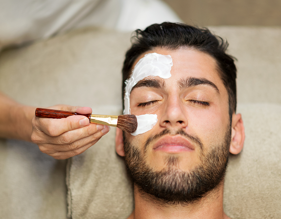 Male client relaxing during a professional chemical peel for men treatment in a modern skincare clinic.