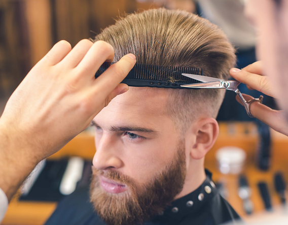 Stylist refining a clean fade on a seated client inside a local barber near Roscoe Village, Chicago.
