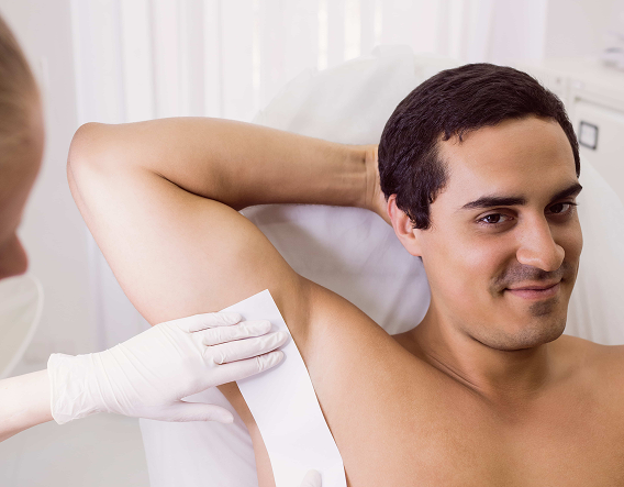 Man receiving a chest waxing treatment in a clean, private men’s grooming studio