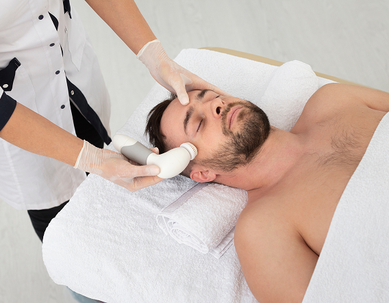 Close-up of a man applying soothing serum, illustrating proper chemical peel aftercare to protect sensitive skin.