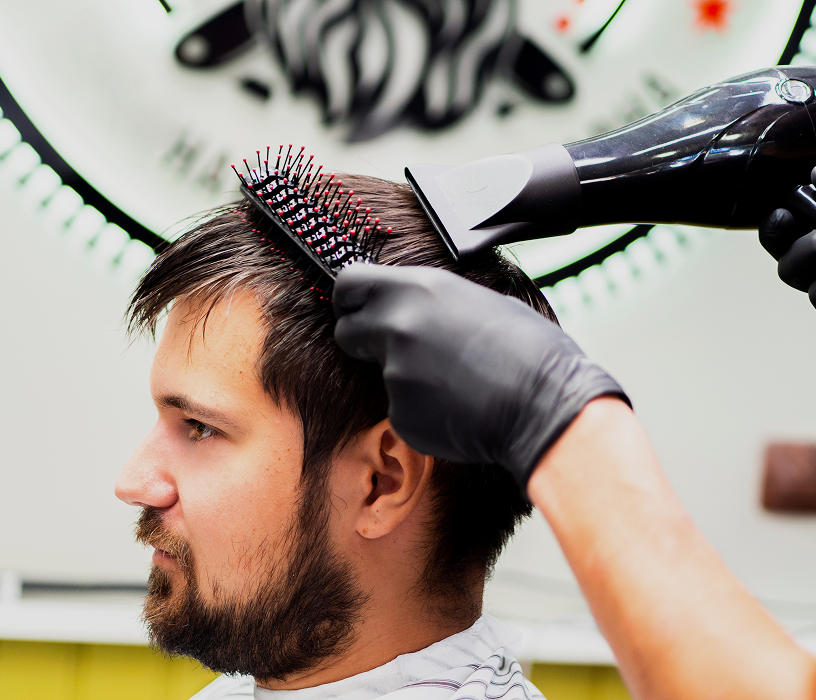Young man with tight curly perm and undercut showing a clean perm for men short hair result on dark hair.