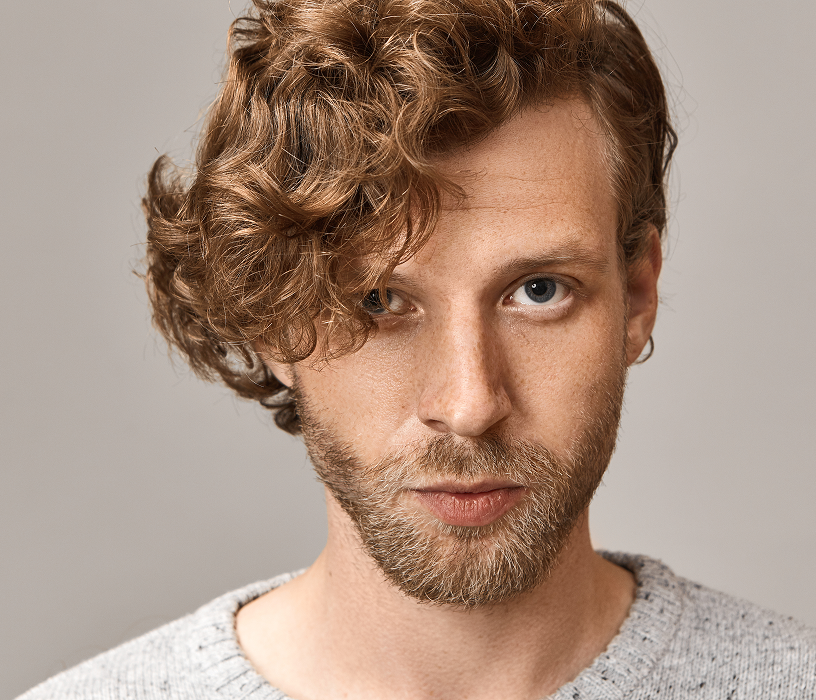 Man getting hair washed at a salon bowl as part of a men's wave perm appointment preparation process.