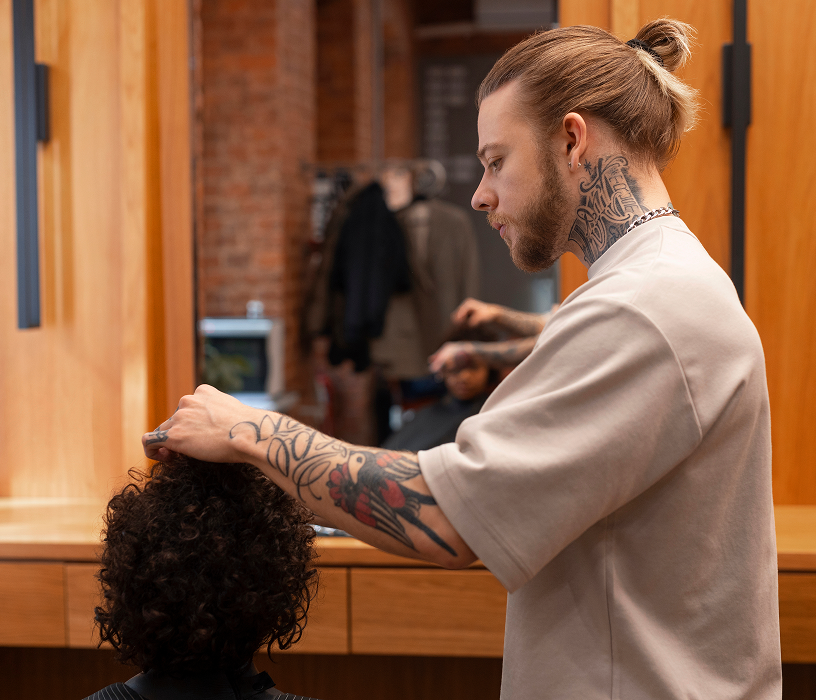 Man in bathroom checking short straight hair in mirror before visiting a men's perm Chicago salon for a consultation.