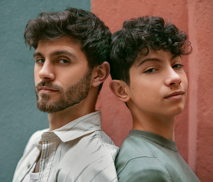 Young man with tight curly perm and fade showing bold men's wave perm results on short to medium length hair.