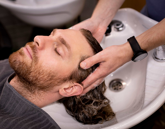 Stylist applying soft, blended balayage in Buena Park to create natural dimension and movement in men’s hair.