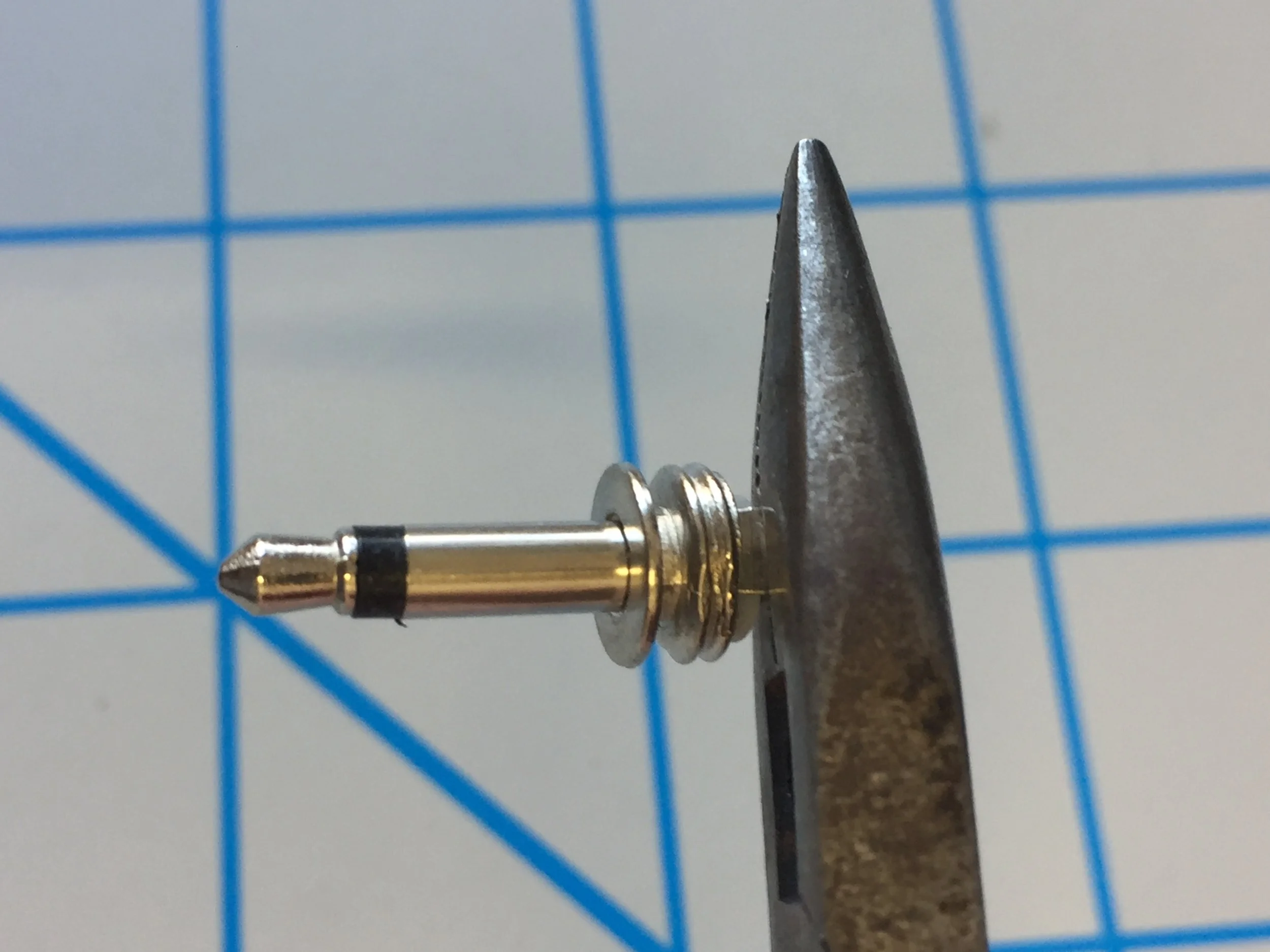 3.  Using your pliers, bend both connection lugs outwards to a 90˚ angle flush with the rim of the white plastic spacer (see image below for additional reference).  NOTE:  There were some units sent out which have a smaller plastic standoff, please take caution while soldering and bending the legs so there is space between the body (threading) of the plug and the solder applied to the solder lug.