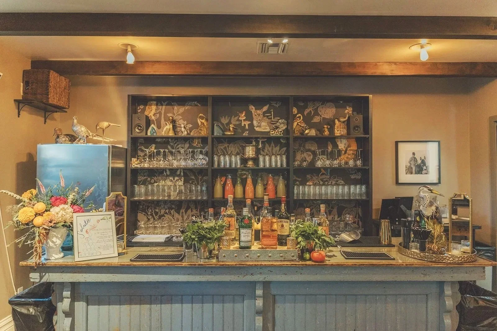 Bottles and glasses line the antique bar ready for cocktail hour at The Lodge at Malibou Lake wedding venue in Malibu, CA.