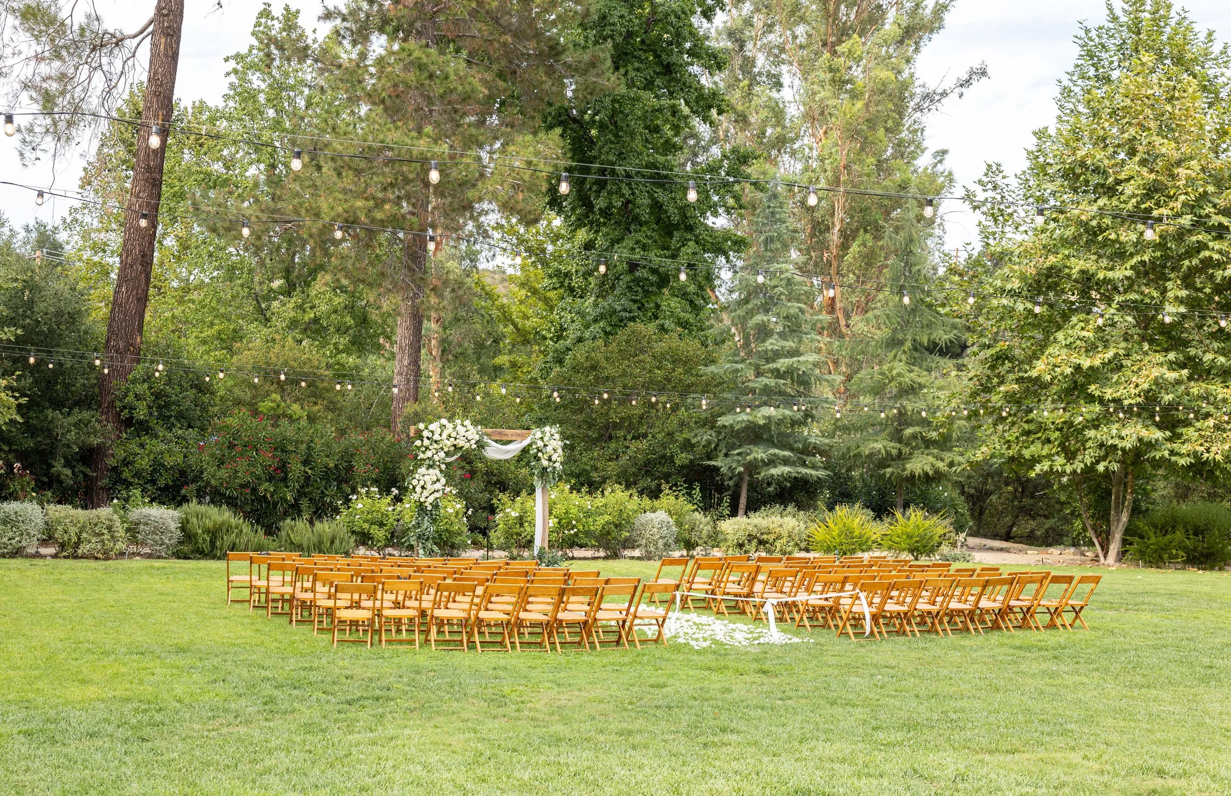 September Wedding: Ceremony chairs and arch set outdoors on the great lawn at The Lodge at Malibou Lake in Agoura Hills CA.
