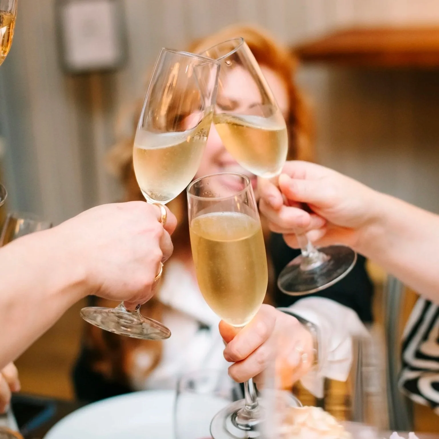 People raising glasses of champagne in a toast at a celebration or gathering.