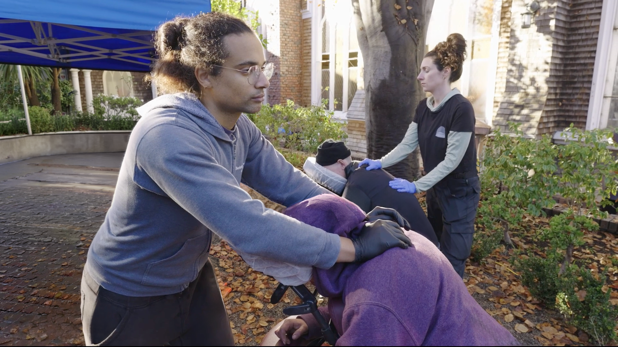 Volunteer massage therapists providing free chair massage to community members in San Francisco.