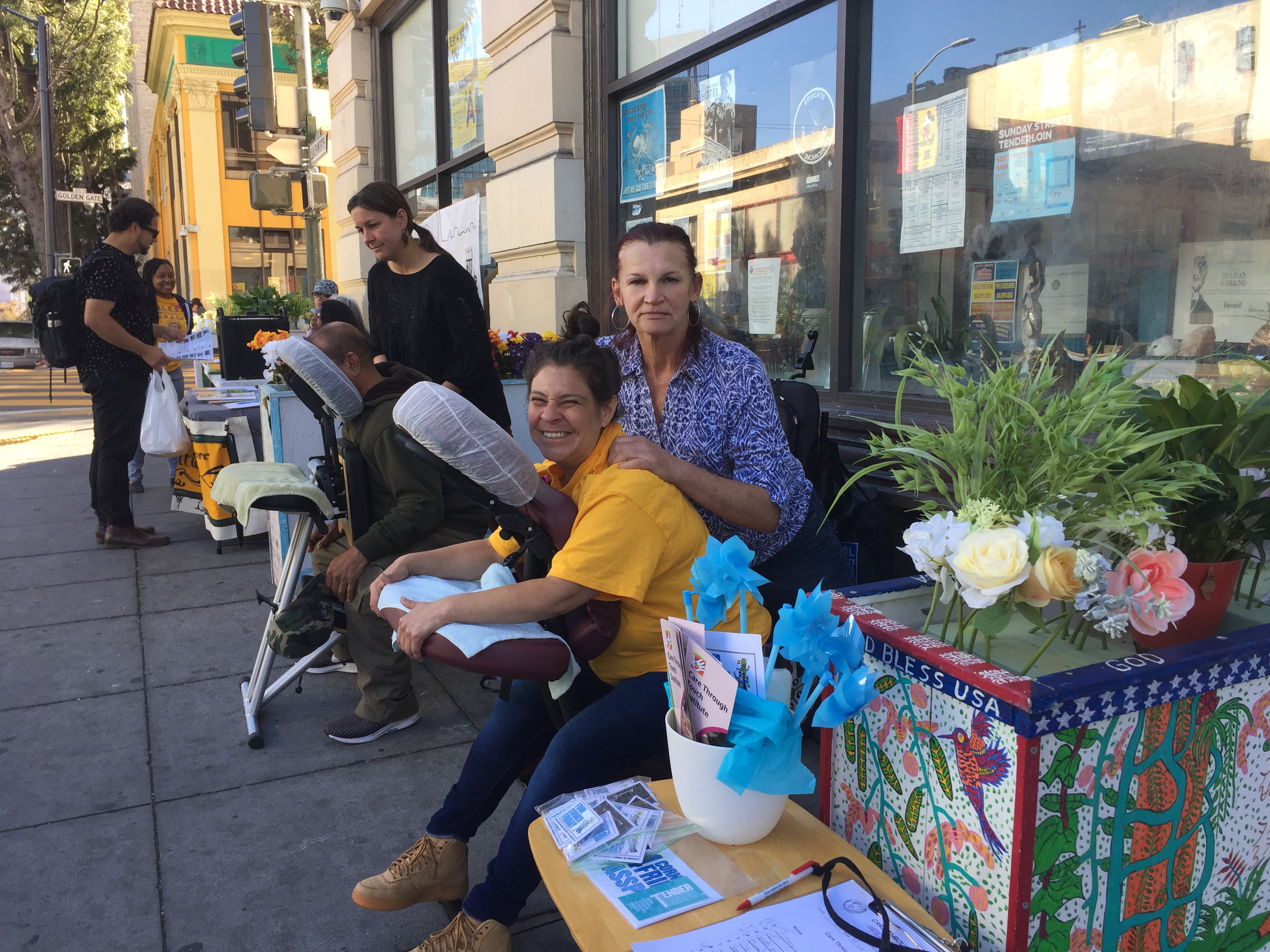 Volunteer massage therapist providing free chair massage to a community member in San Francisco.
