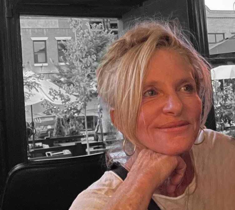 A photo of Laura Greenfield, owner and Architect of Greenfield Architects sitting indoors near a window.