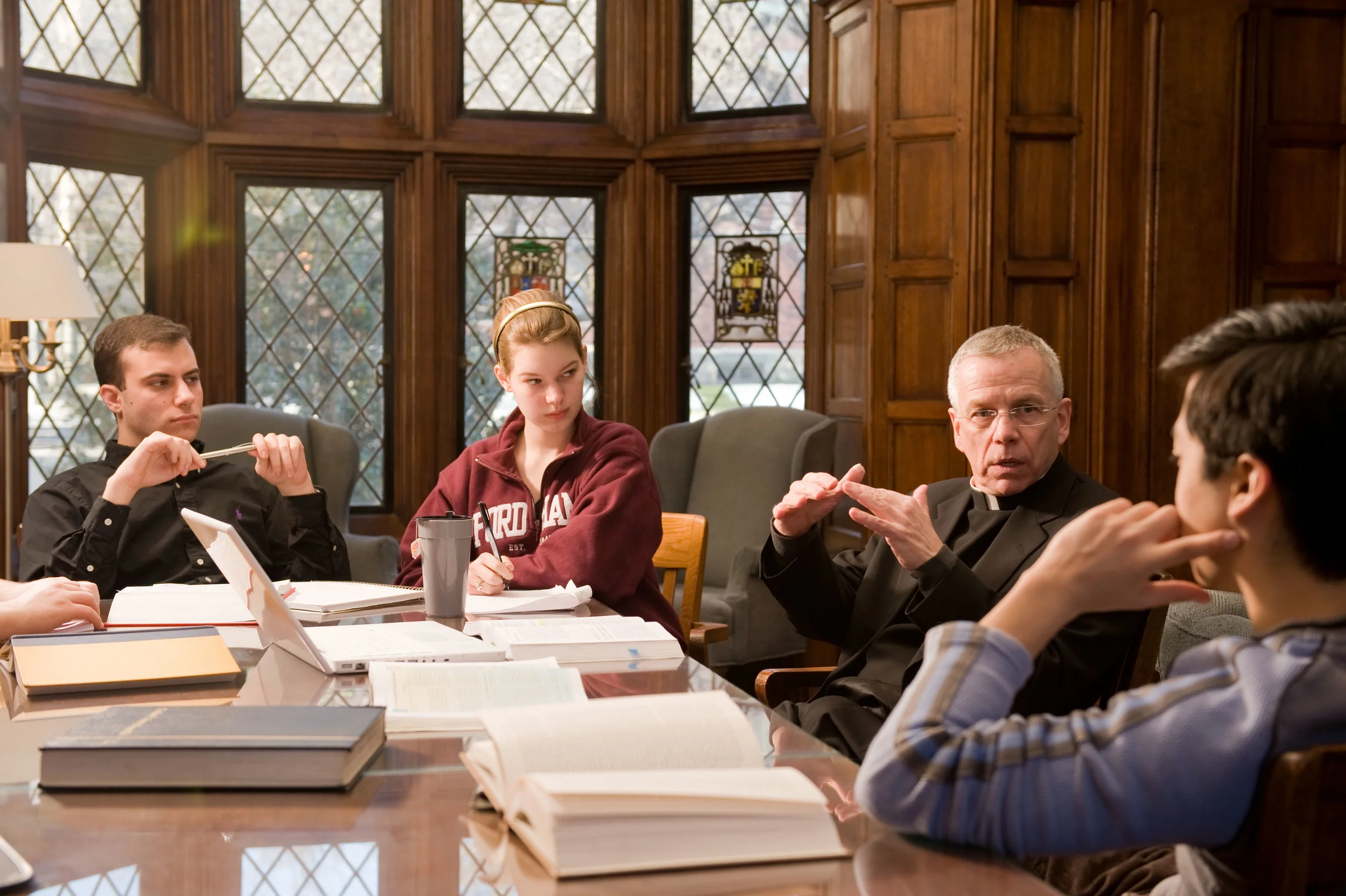 Students in a classroom discussion with Fr. David Marcotte SJ at Fordham University . 