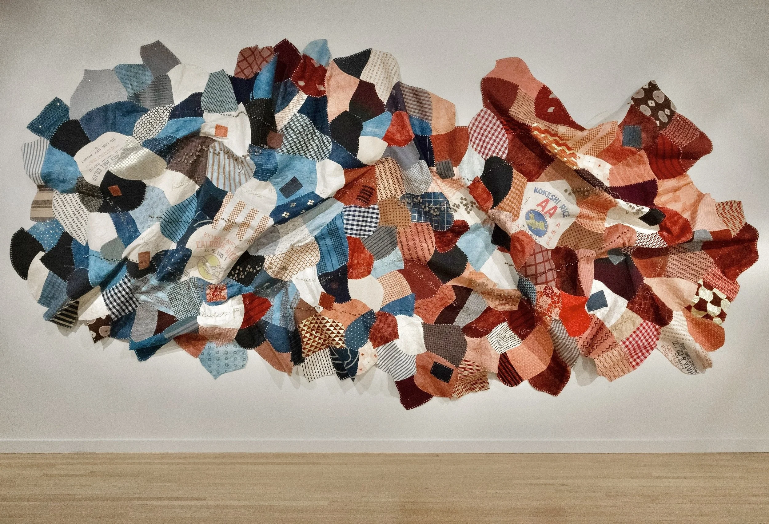 Still Finding My Way Back Home. Kapa, reclaimed Japanese fabrics, indigo and madder root dyes, ceramic beads, bells, earth pigments, hand-embroidery. Approx. 9 feet H x 17 feet W. 2025.