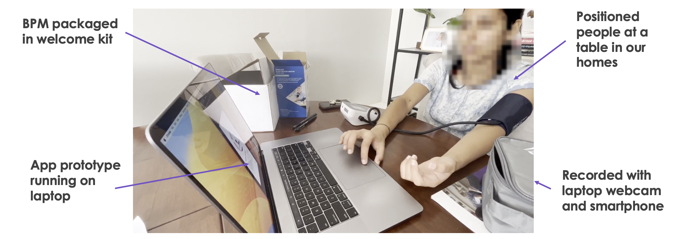 A person wearing a blood pressure cuff using a laptop