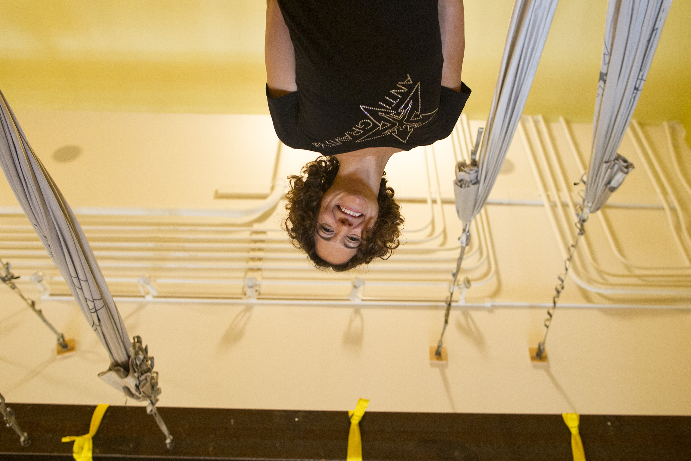 Yoga instructor Marcie Evans, seen from an inverted angle from an AntiGravity Yoga hammock, poses for a photo at Serenity Yoga & Pilates Studio in Iowa City.