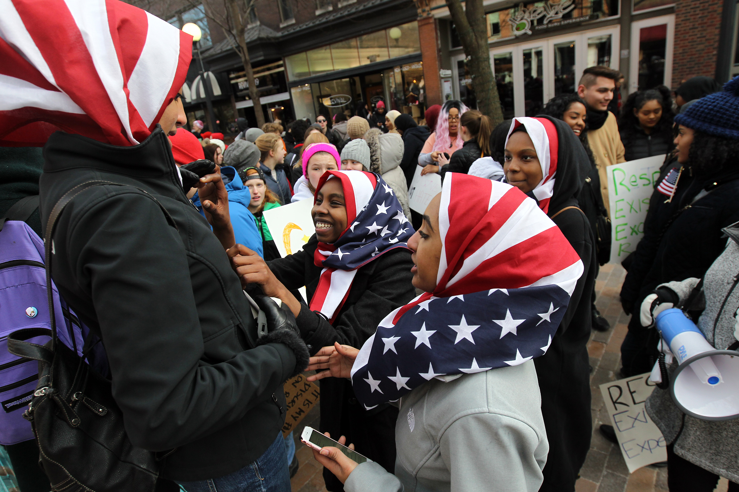 West High senior Ala Mohamed, center, jokes with classmates before leading a march on the pedestrian mall during a rally against President Trump's travel ban.