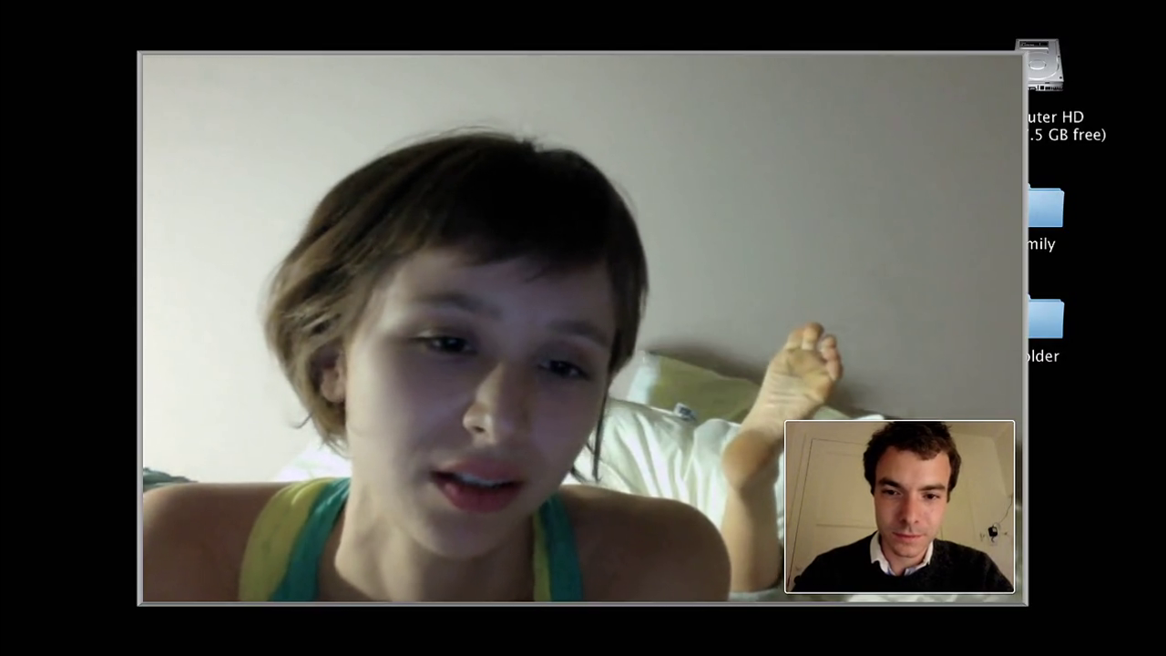 A folder named "Emily" barely covered by the video feed Emily herself suggests sinister ulterior motives of her boyfriend whose computer screen we are looking at.