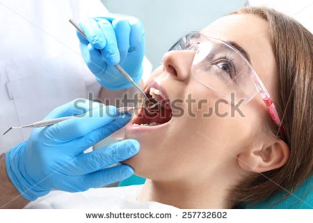 stock-photo-overview-of-dental-caries-prevention-woman-at-the-dentist-s-chair-during-a-dental-procedure-257732602.jpg