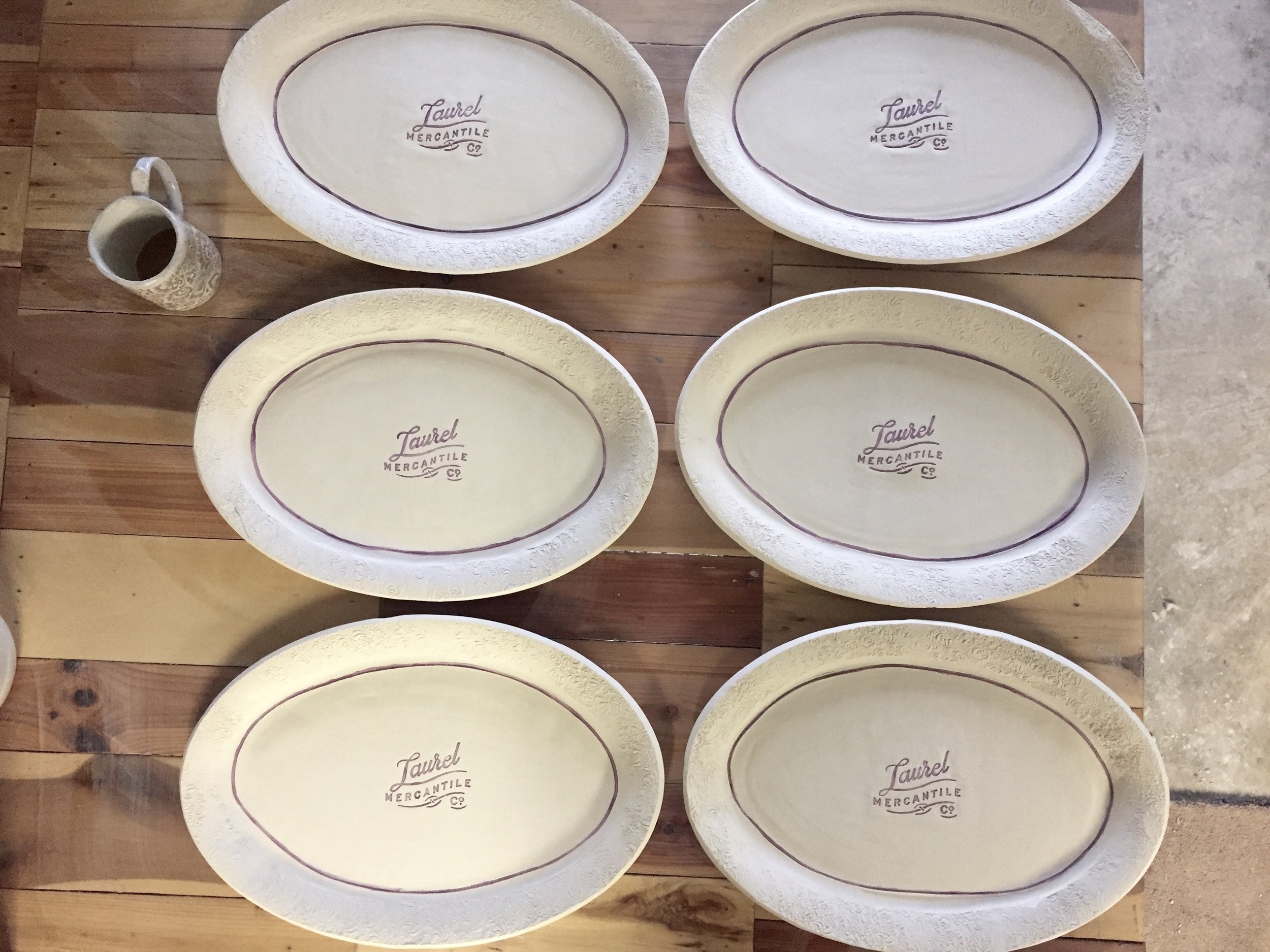 Bisqued Laurel Mercantile Co. platter. The hand painted "purple" underglaze turns a vibrant navy blue during the glaze firing. 