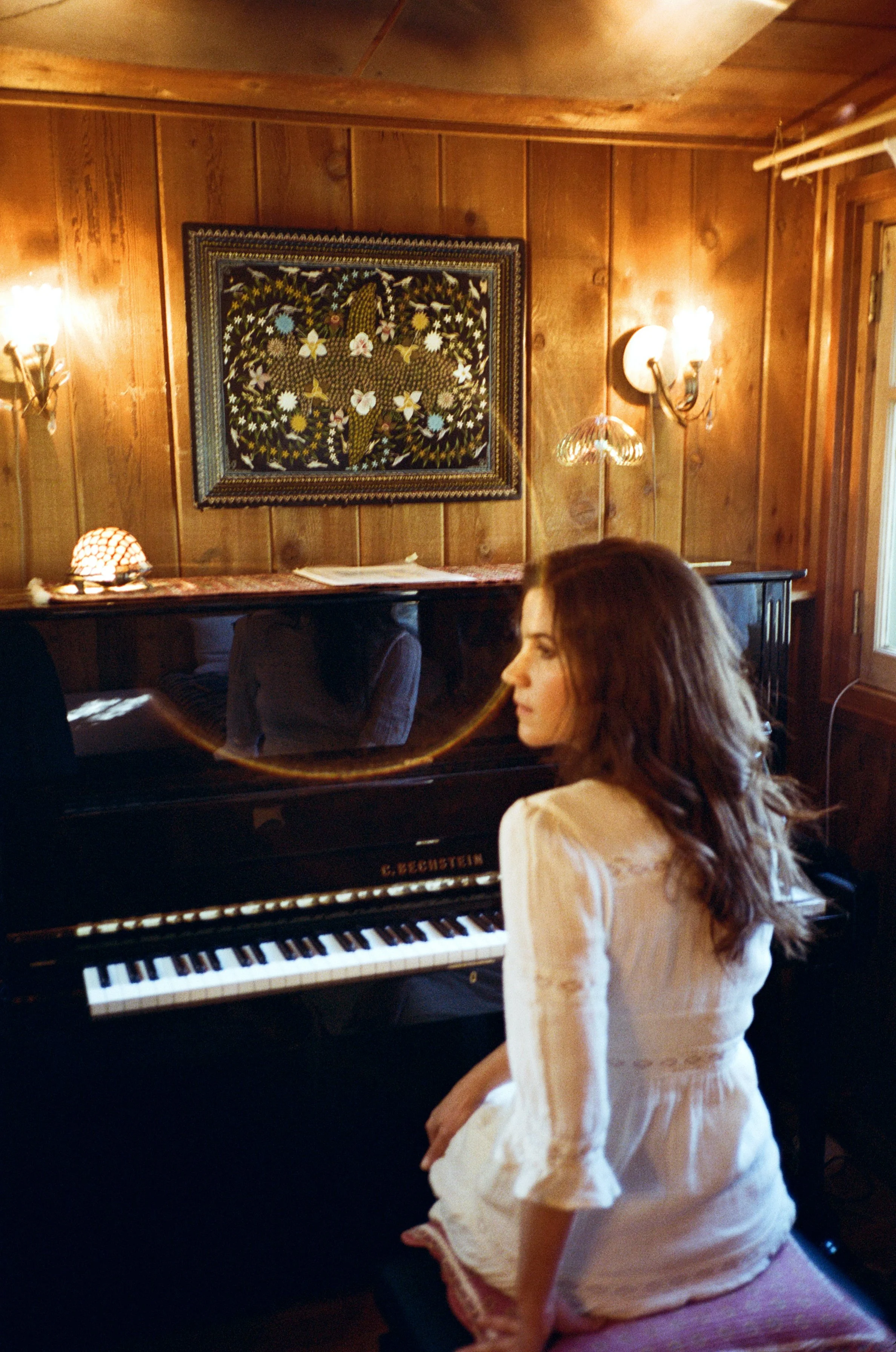 Erin Durant at the piano with rainbow