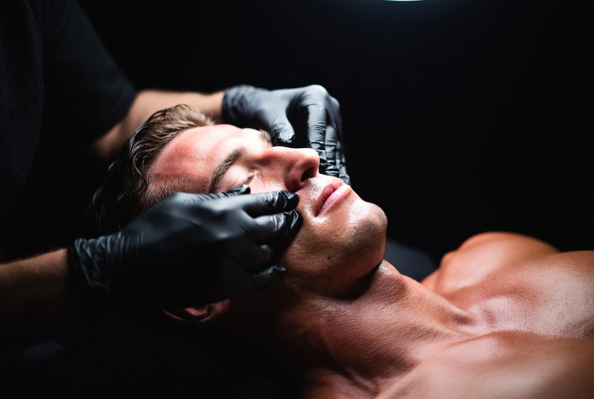 Man receiving professional facial extractions during a men's facial treatment at Conjure Skin Therapies