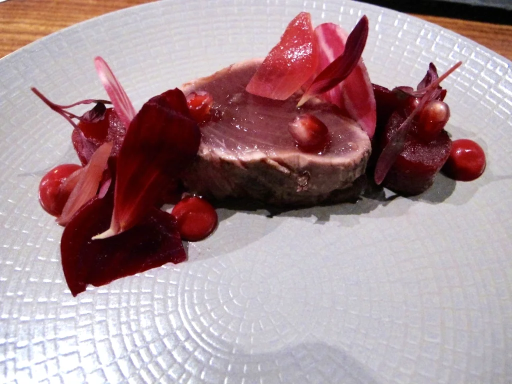 Bonito with pomegranate, beets, pink peppercorns, Meyer lemon, and hibiscus petals grilled tataki style