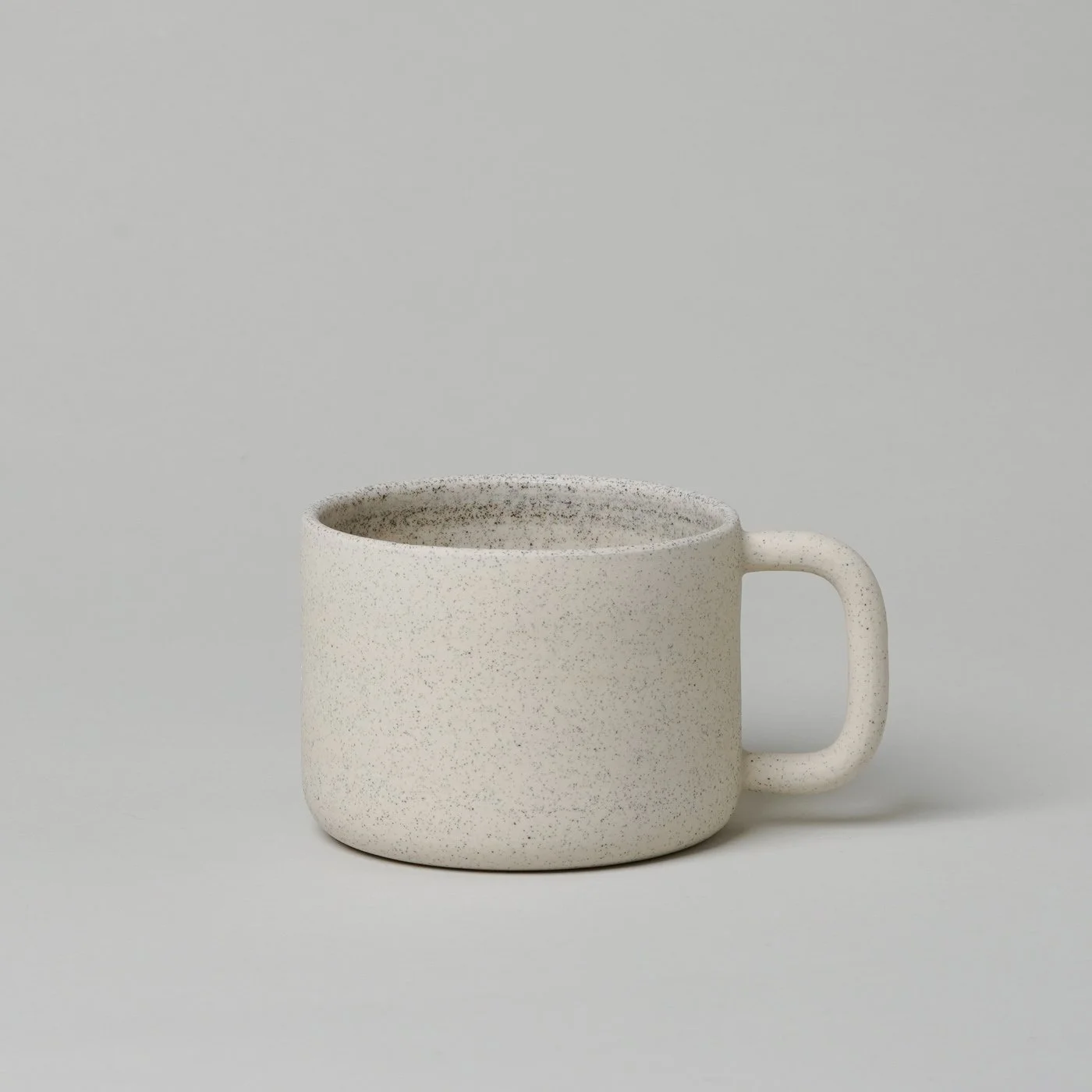 product image of a white speckled, minimally designed, handmade mug