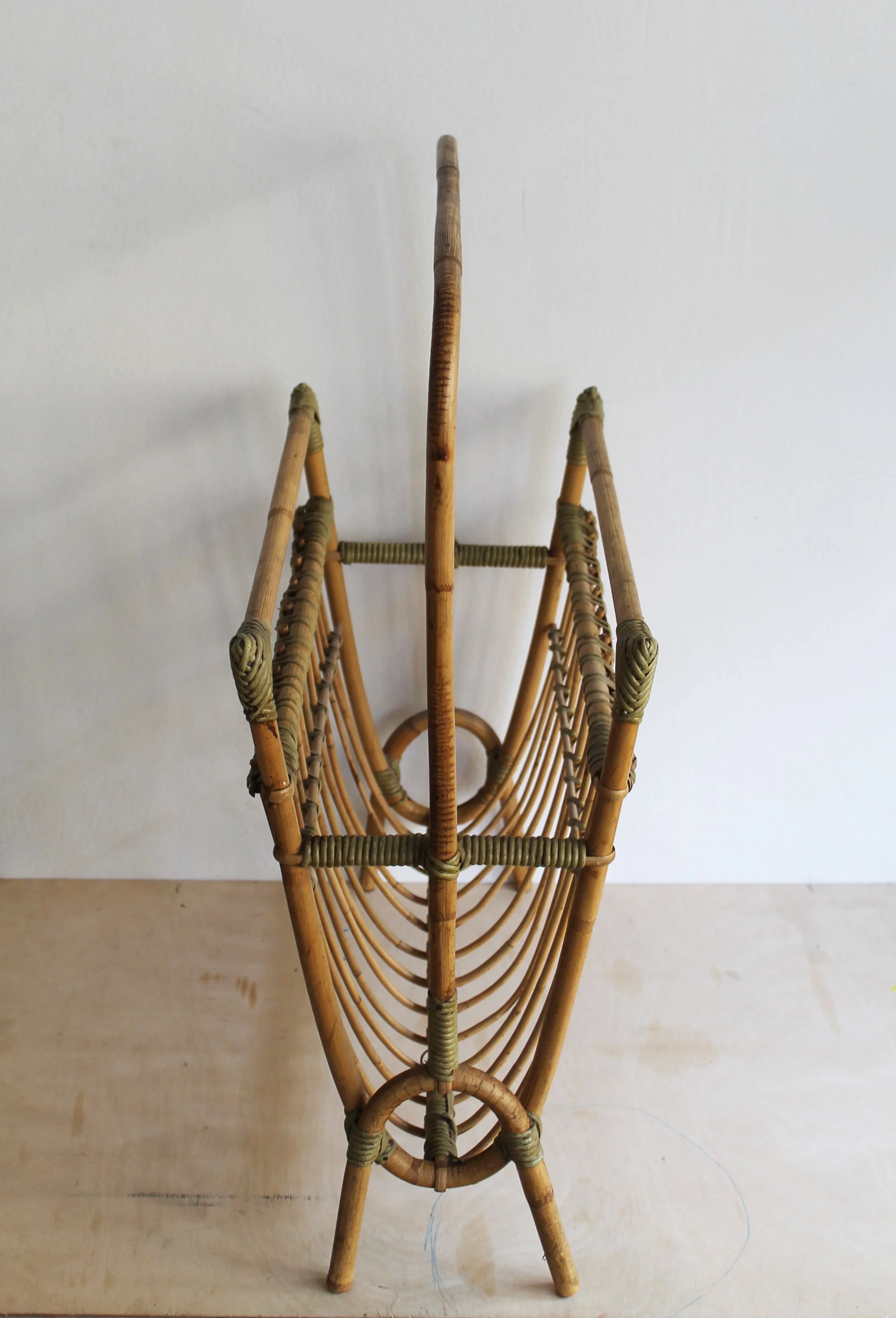 Three-quarter view of 1960s Czechoslovak rattan magazine rack showing its open double-compartment construction