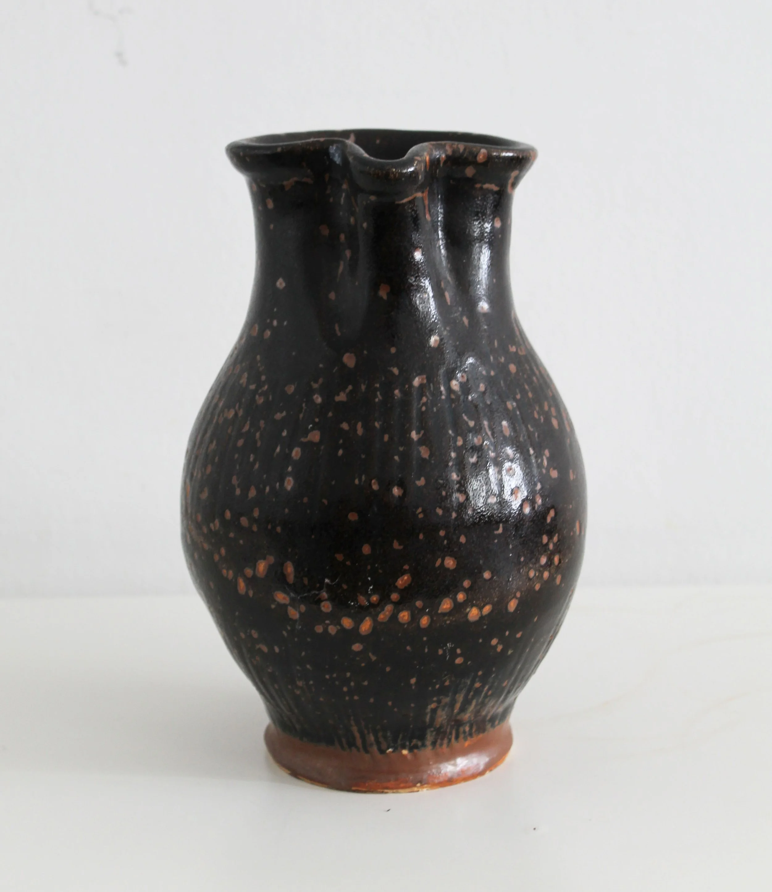 Antique pitcher made of dark glazed stoneware