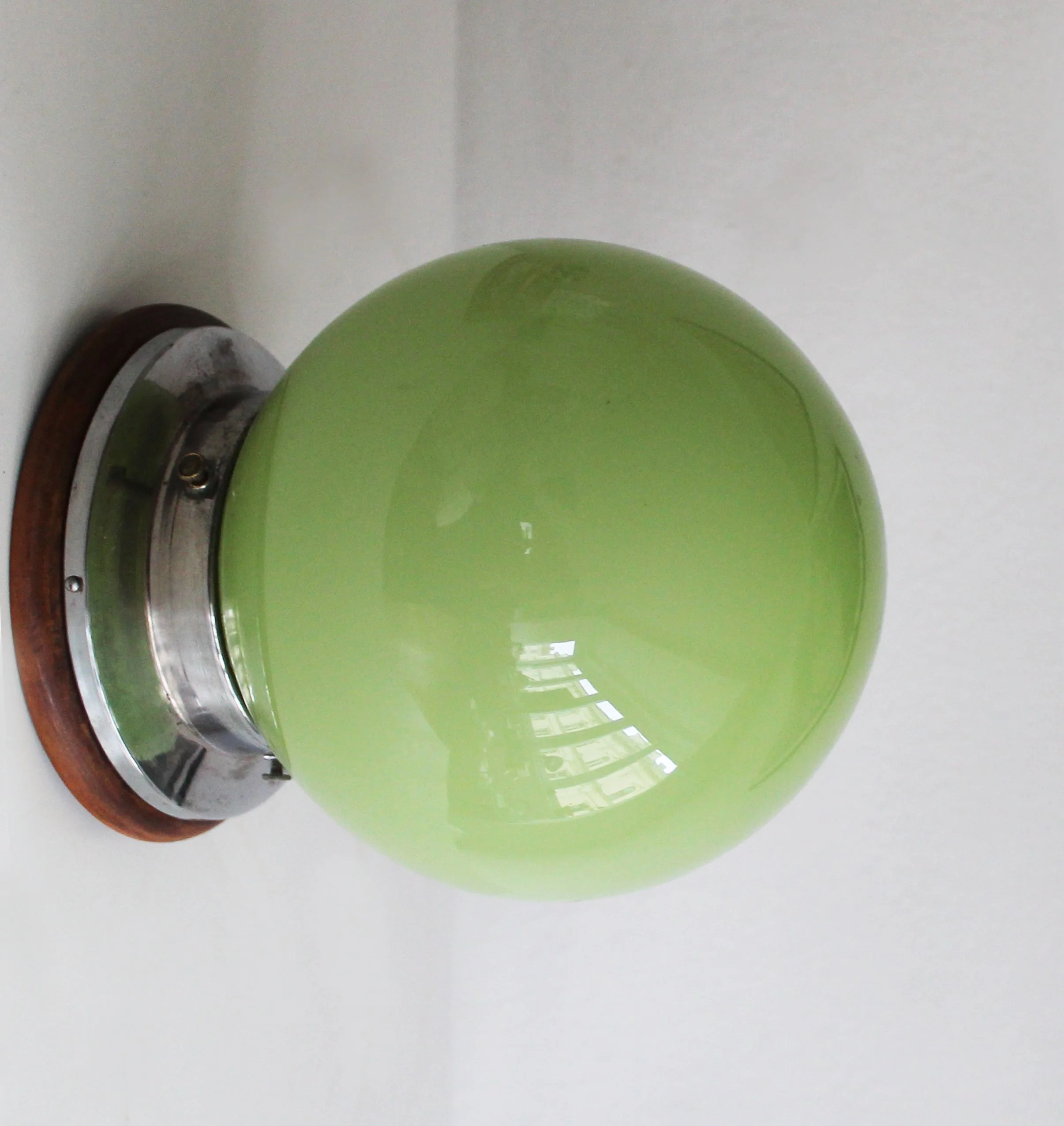 Czech Bauhaus-style ceiling lamp featuring green globe and wooden mounting base.jpg