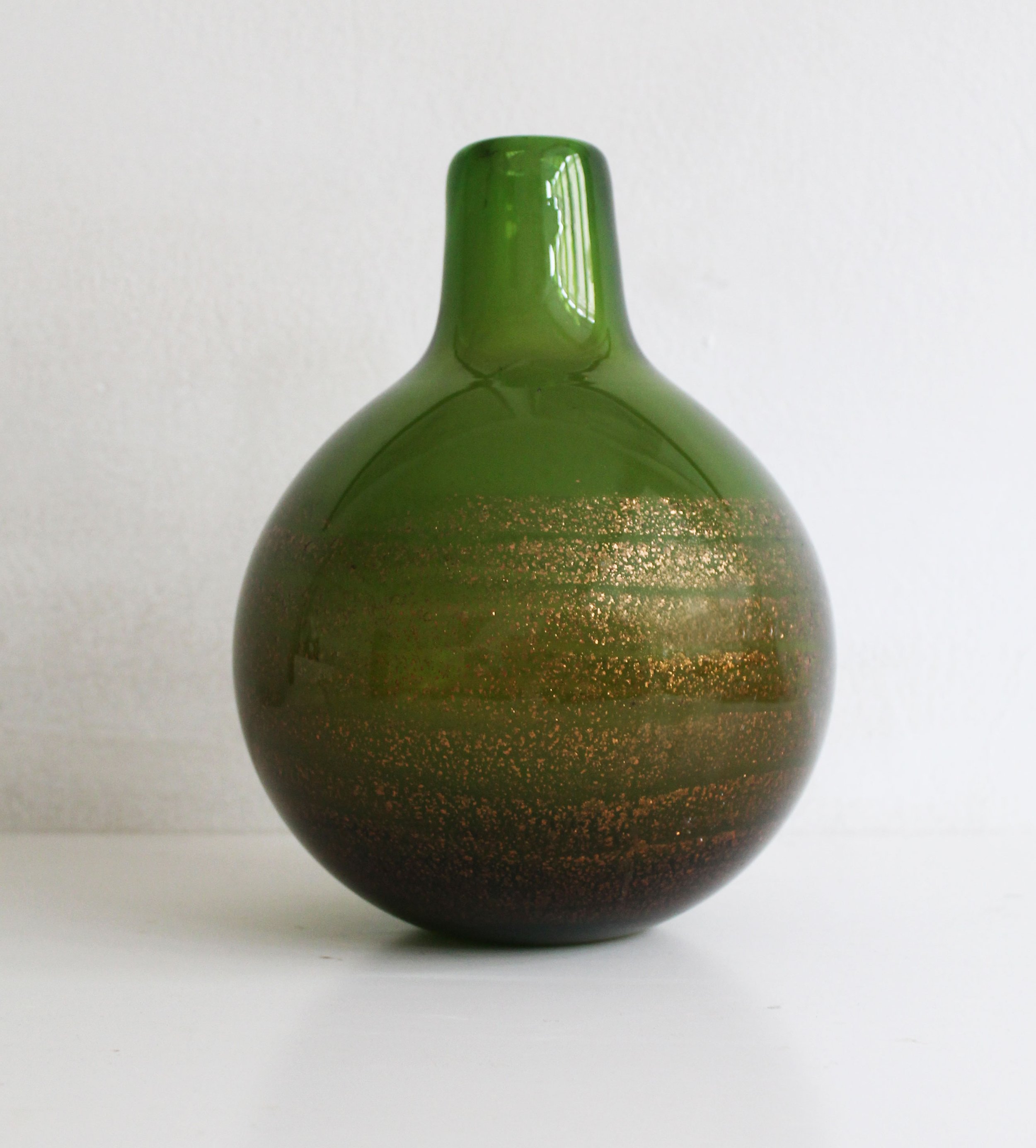Close-up of 1970s Czech art glass vase showing glittering mica layers sealed in thick green glass.jpg