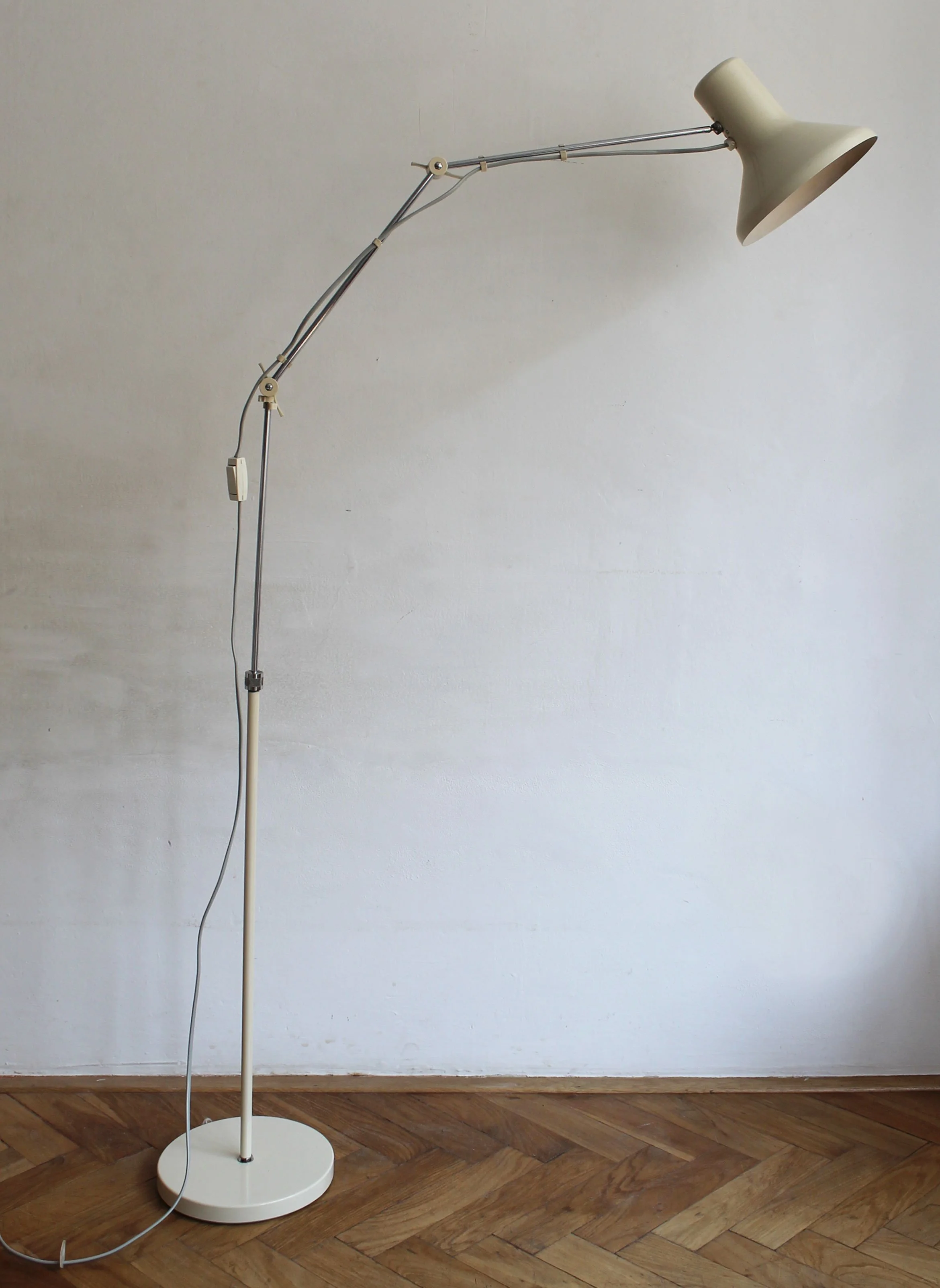 Lamp angled in reading position, with shadow cast on white wall.