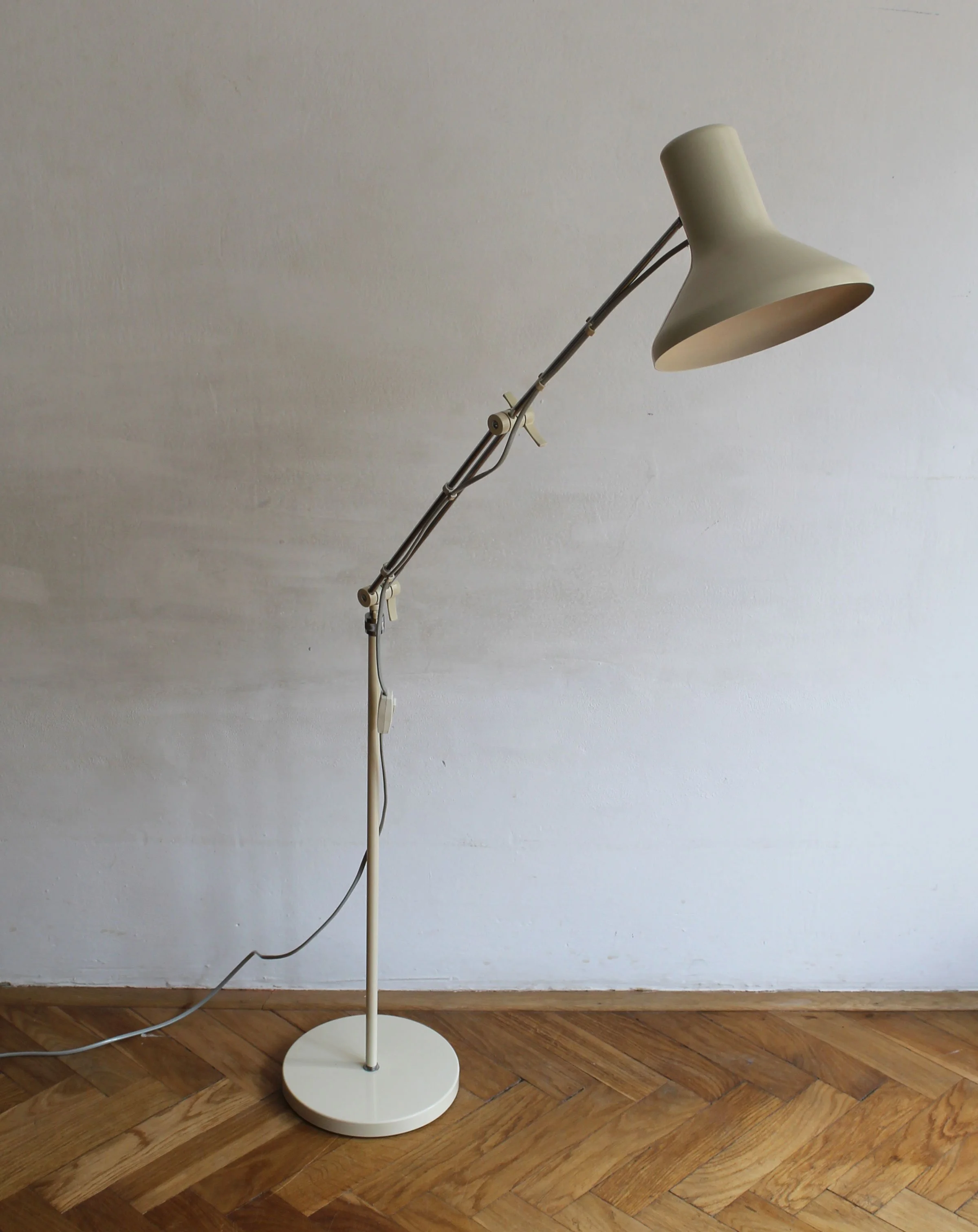Close-up of lamp head with beige conical shade and cream-painted interior