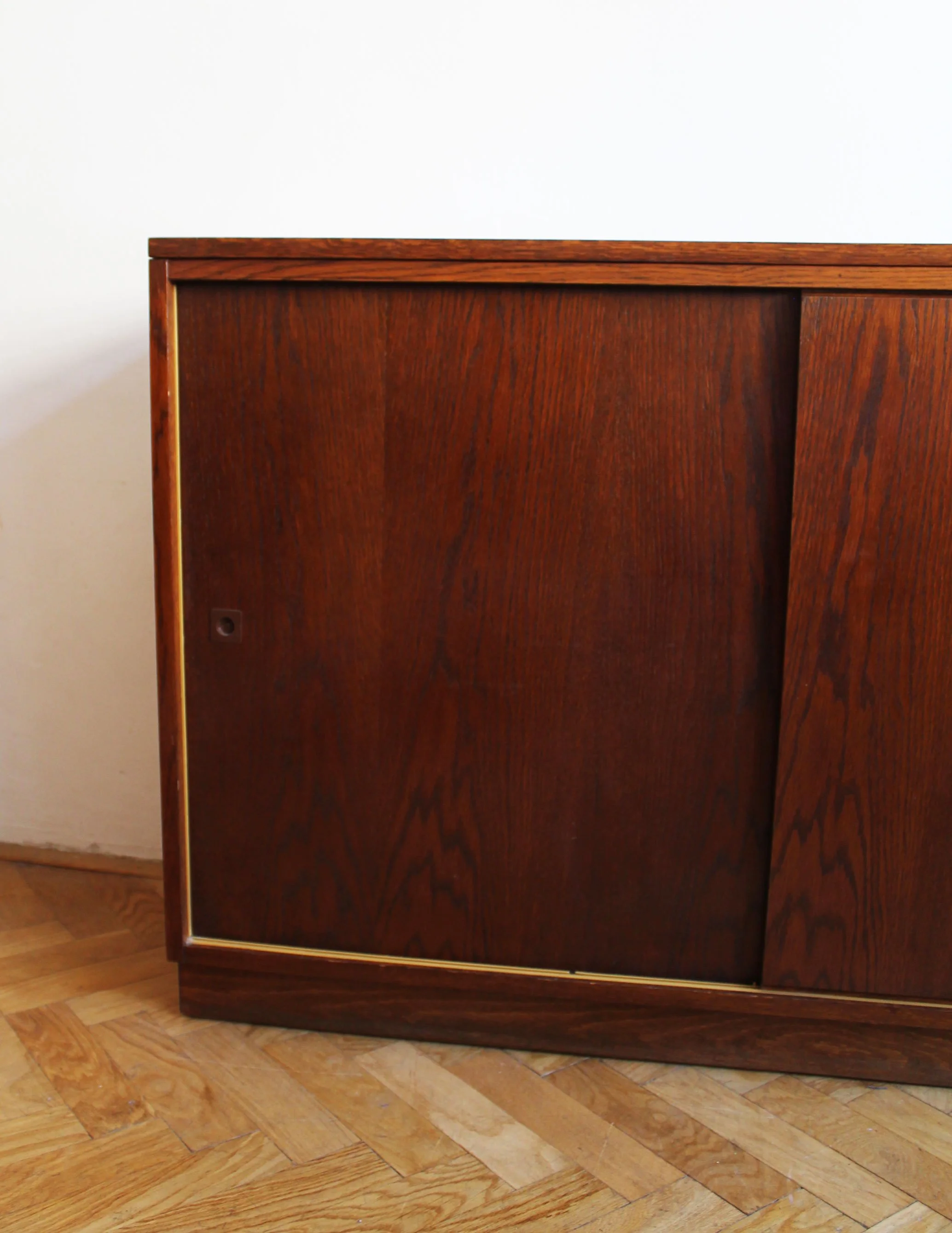 Recessed plinth base beneath a 1960s UP Závody oak sideboard.jpg