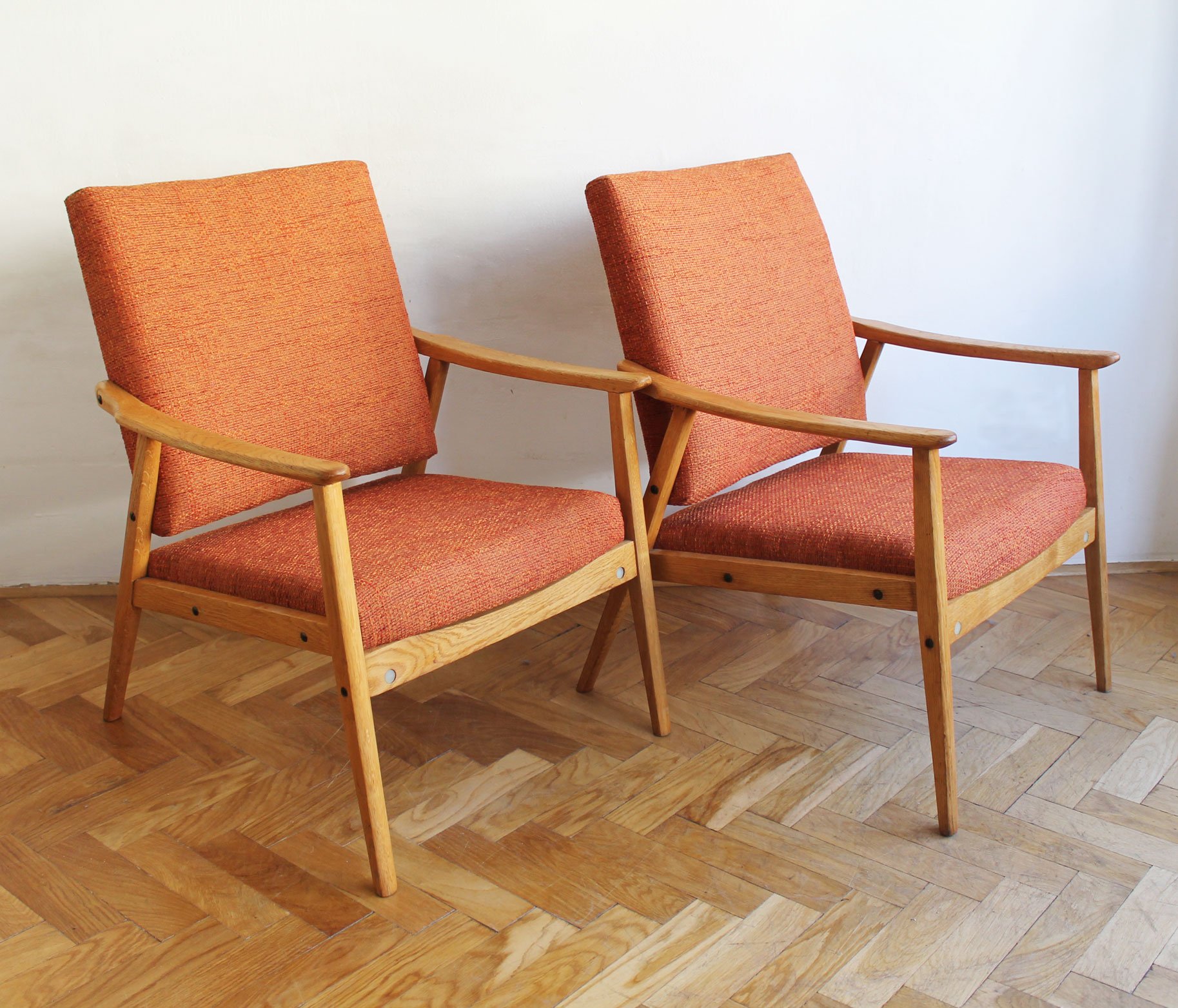 Side view of mid-century armchair highlighting sculptural wooden armrest.jpg