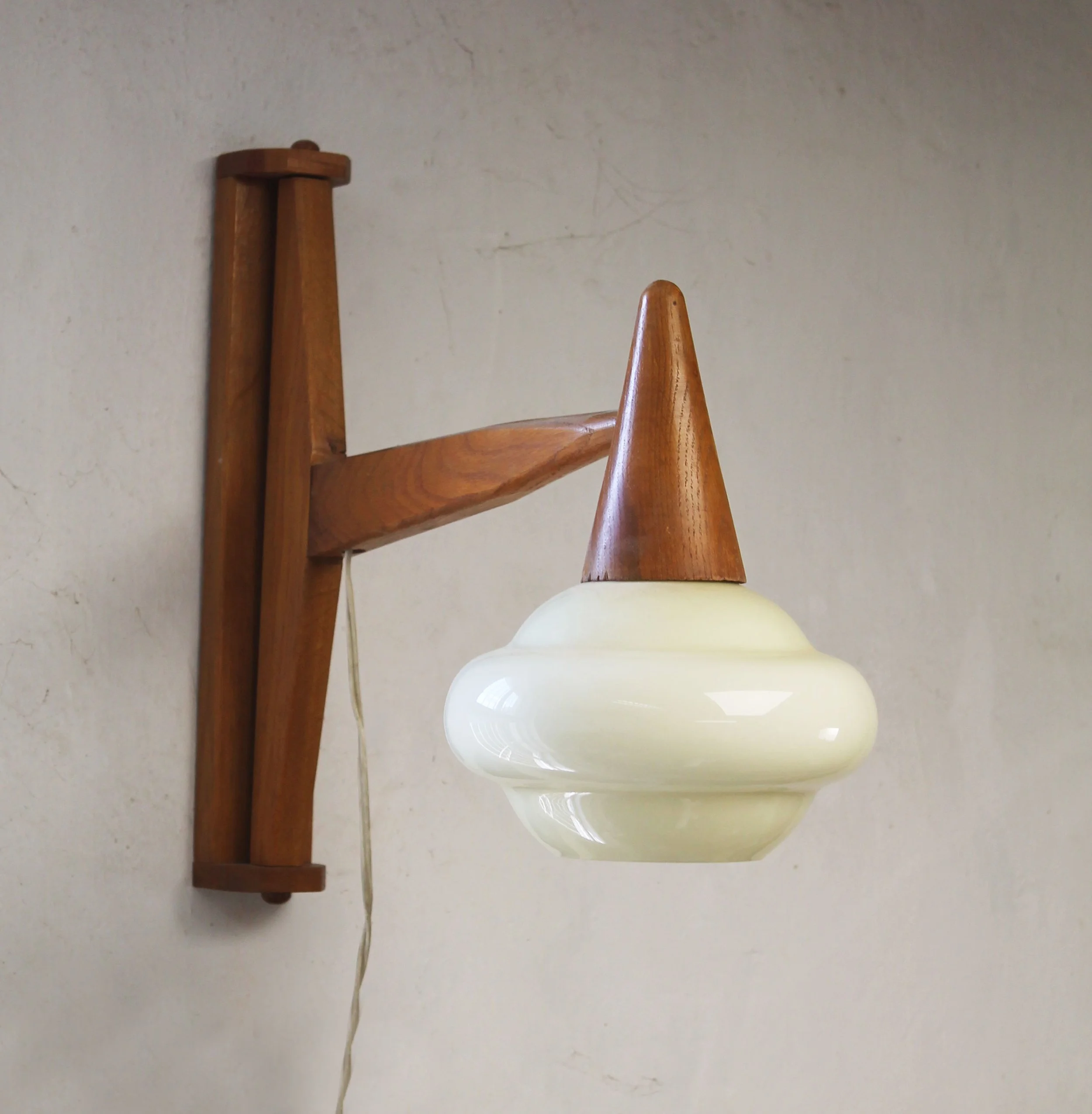 Mid-century wall light showing the warm wood grain and sculptural glass diffuser.jpg