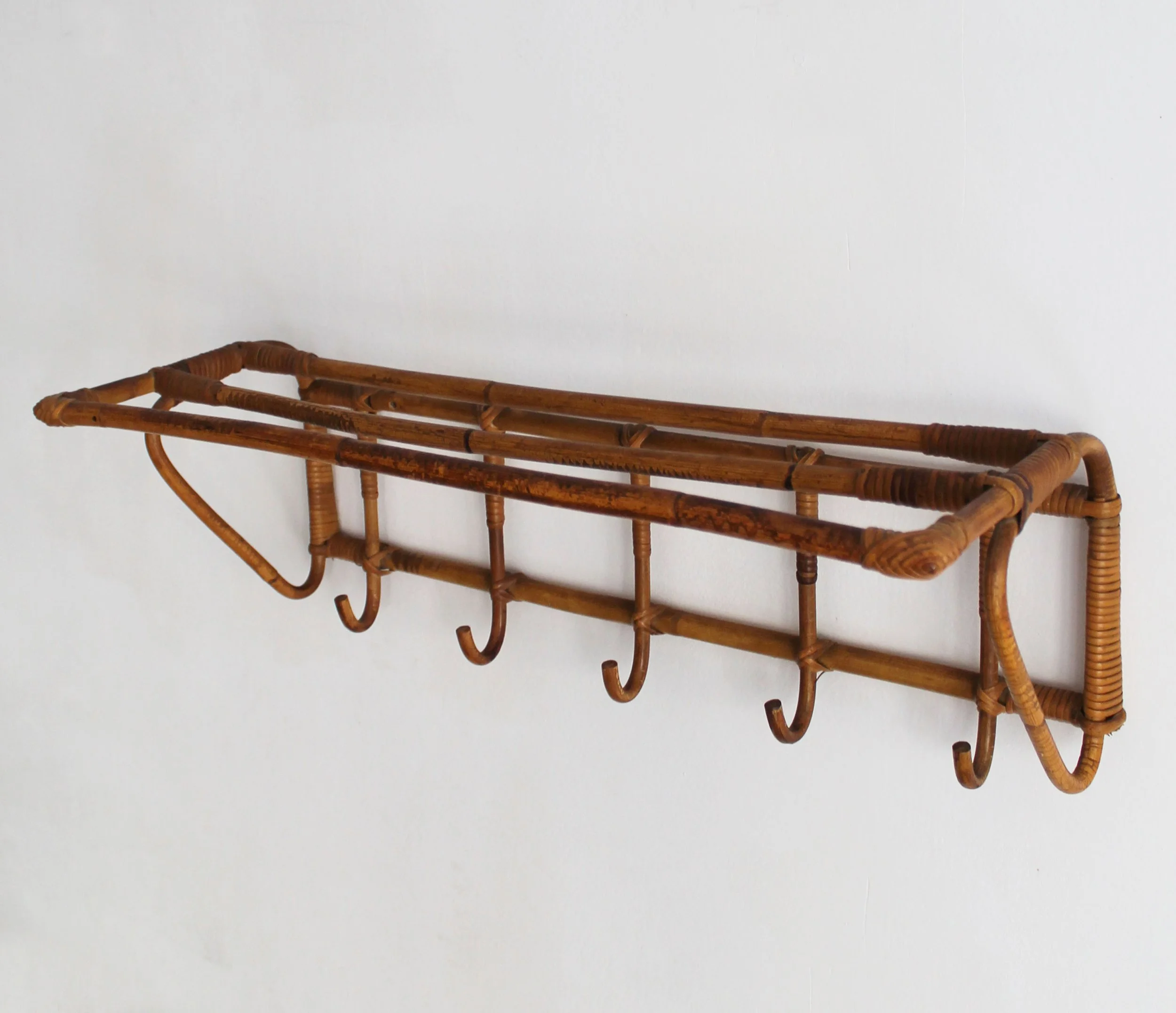 Sculptural bent cane corner and wicker bindings on vintage ÚLUV attributed wall rack.jpg