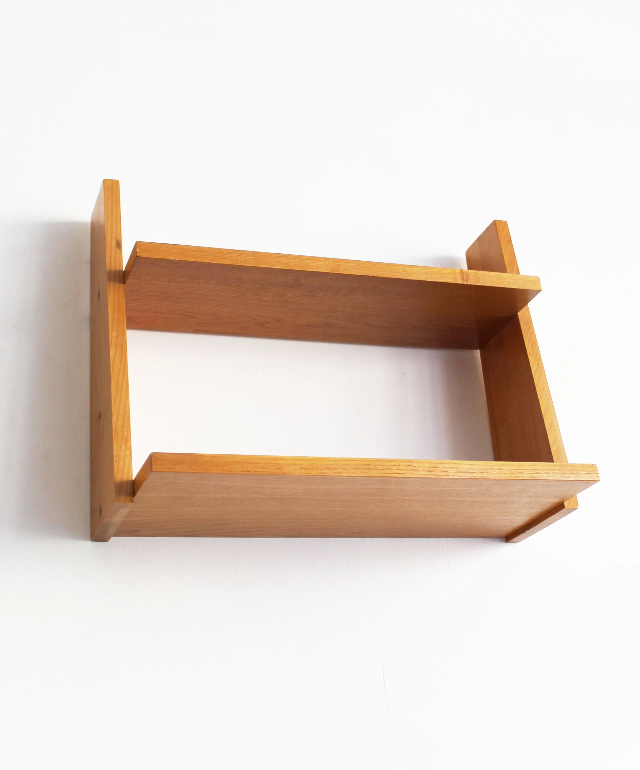 Low-angle detail of 1960s wooden wall shelf showing its sculptural geometric construction