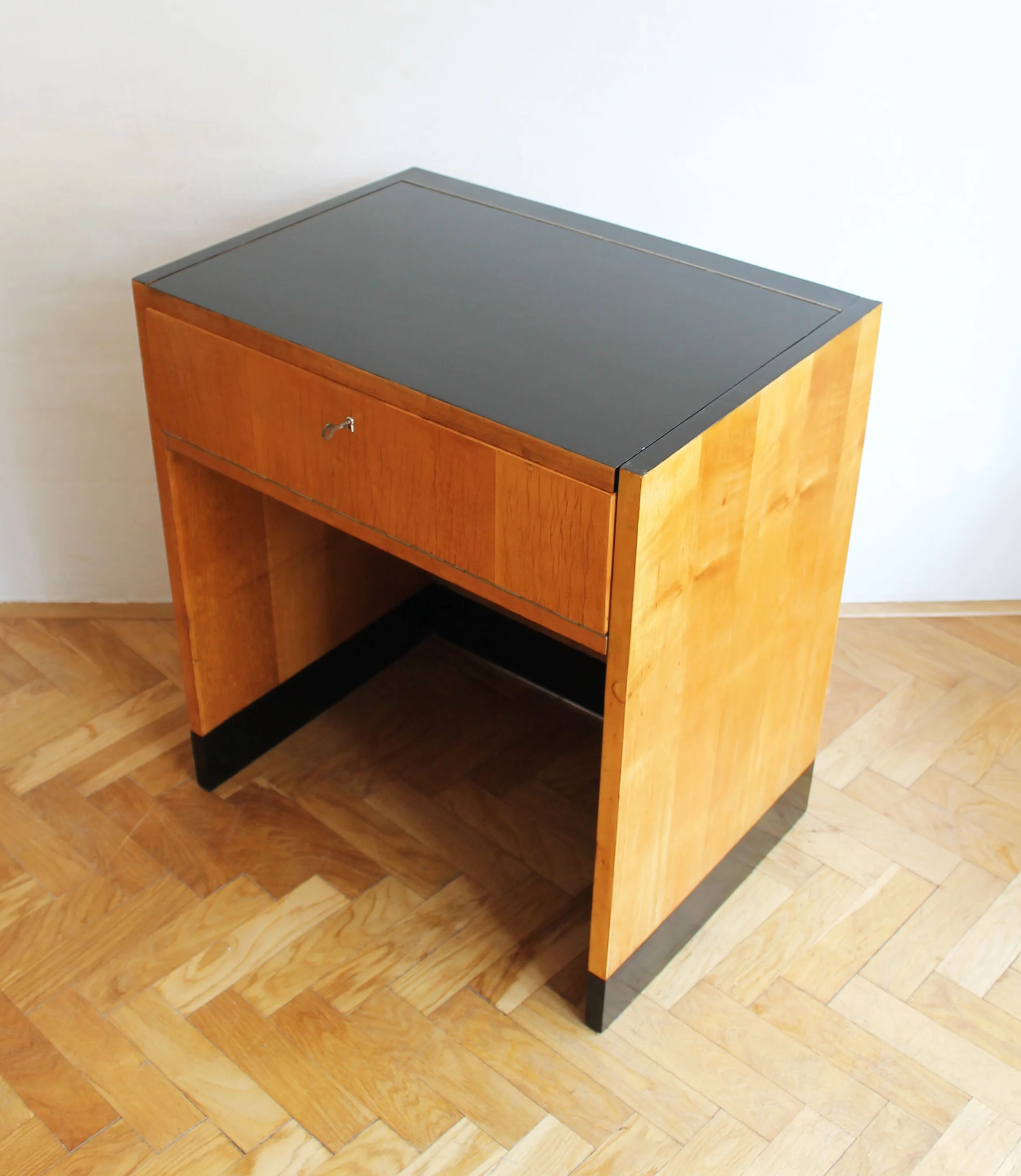 Side angle of a vintage Modernist vanity in birch wood with black-painted base, 1950s design.