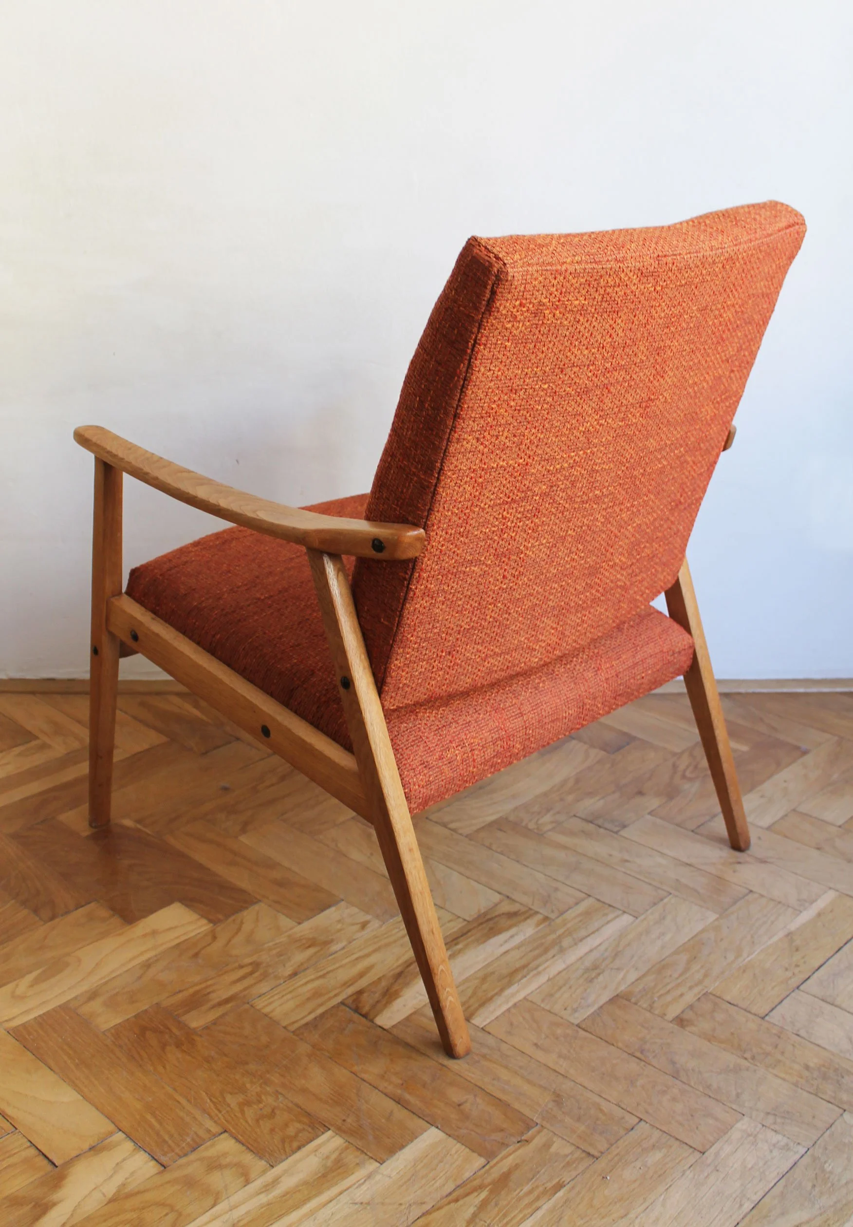 Sculptural wooden backrest supporting padded seat on mid-century chair.jpg