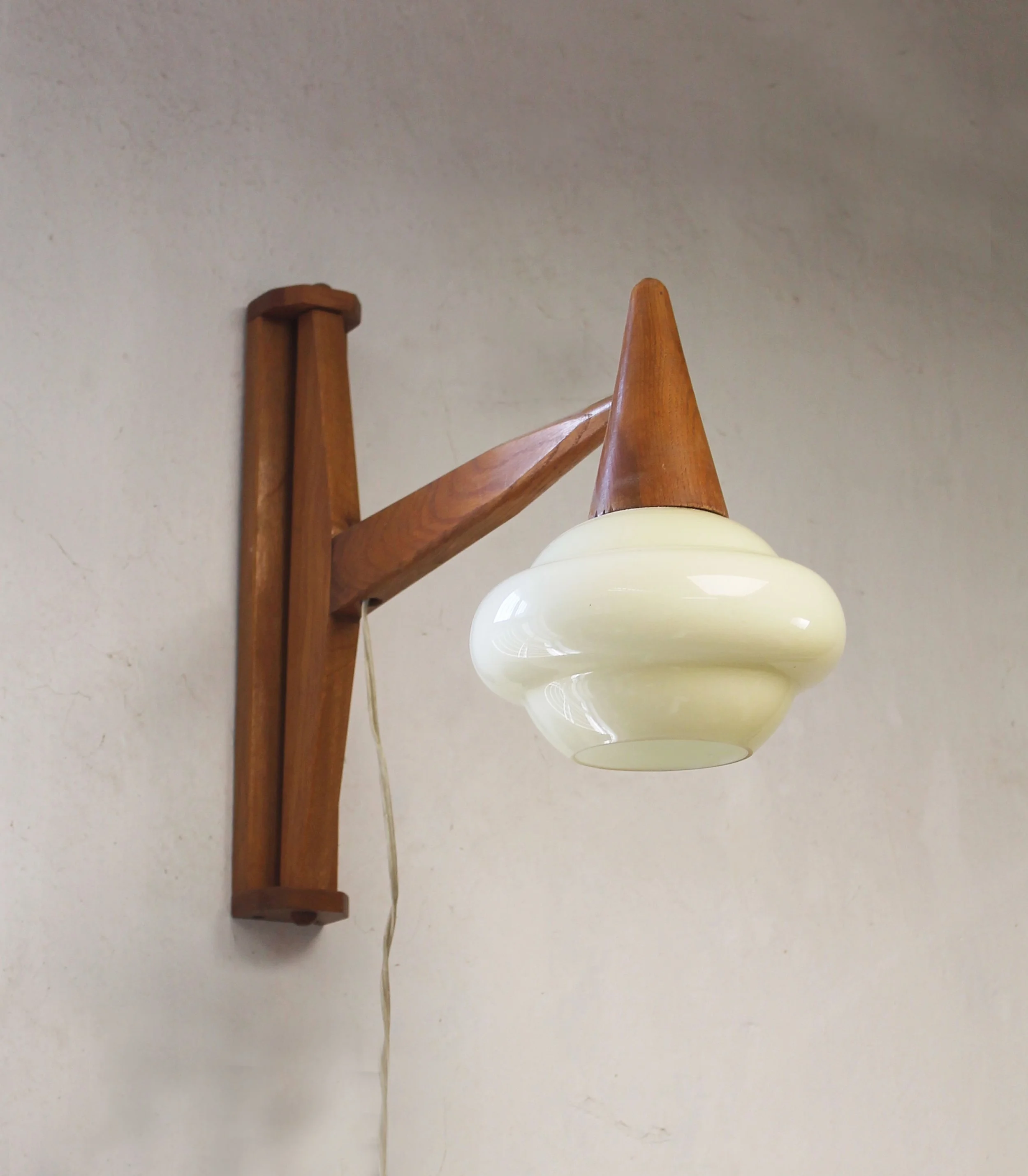 Czechoslovak mid-century wooden wall light mounted with its arm in an angled position.jpg