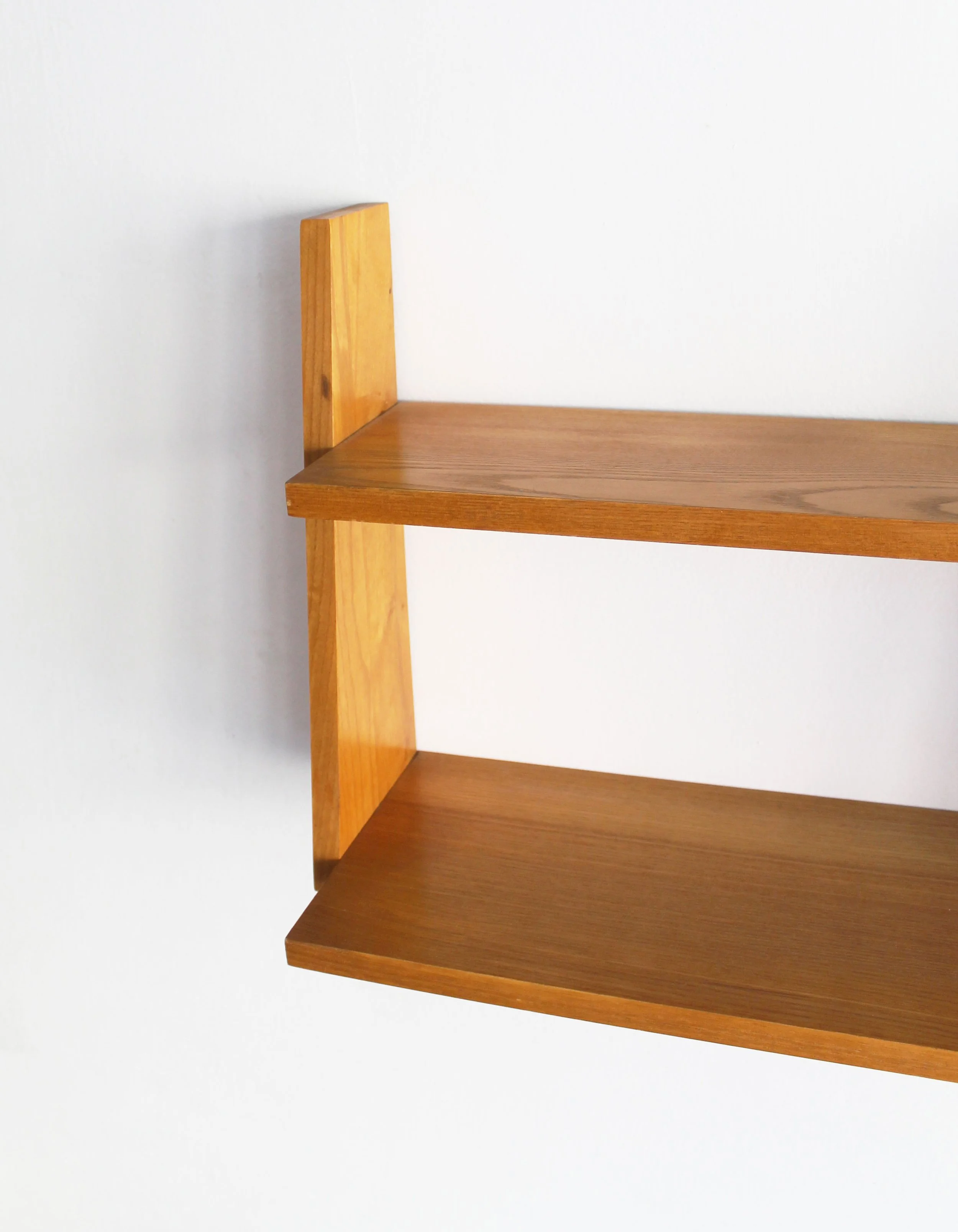 Close-up of vintage Czechoslovak wall shelf showing warm beech grain and angled side support